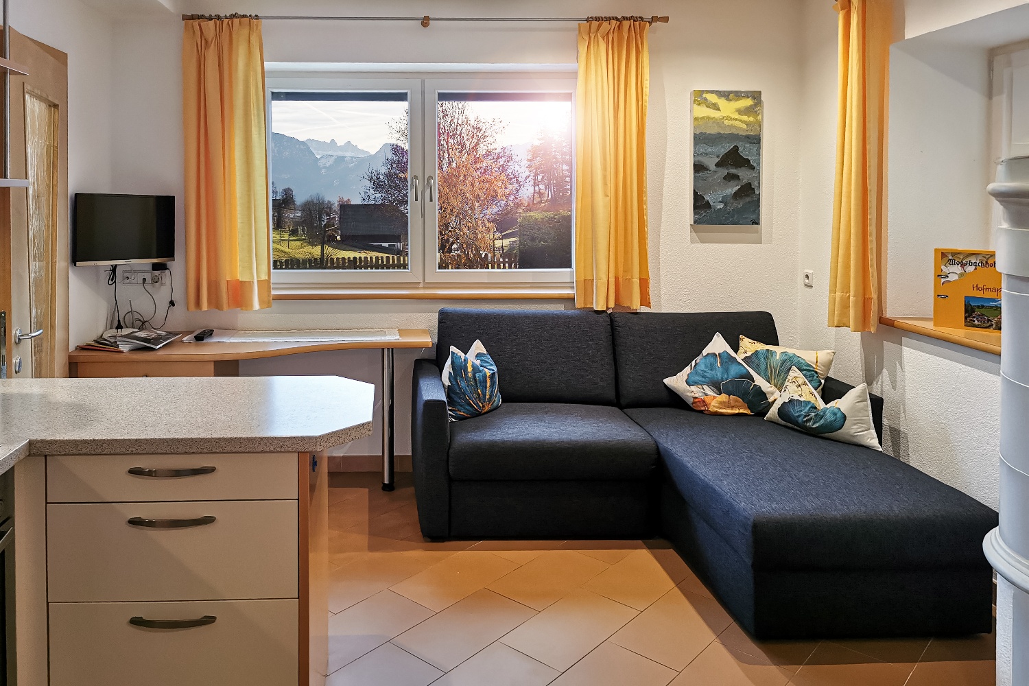 Accogliente cucina-soggiorno con divano comodo e vista panoramica sullo Sciliar.