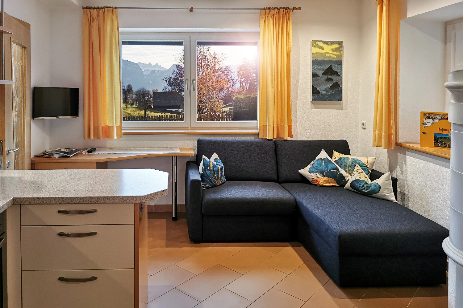 Gemütliche Wohnküche mit komfortabler Couch und Panoramablick auf den Schlern.